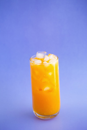 Orange juice splashing isolated on a color background.の写真素材
