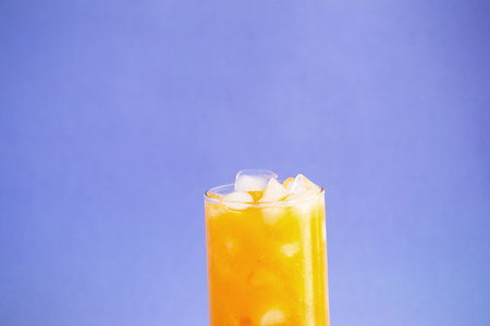 Orange juice splashing isolated on a color background.の写真素材