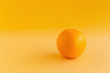 Glass of orange juice freshly squeezed on an orange background.の写真素材