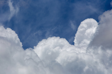 White fluffy clouds in the blue sky background.