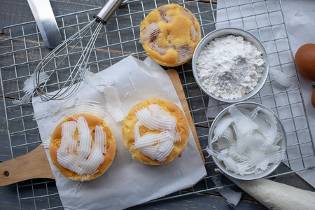 Cook preparing a sweet cake topping Coconut meat on it.