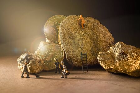 macro miner figures working on group of Bitcoin mining in deep golden cave. virtual cryptocurrency mining concept.の写真素材