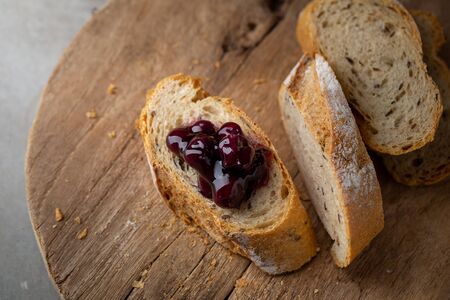 Fresh Homemade Sliced French Baguette Bread with blueberry jam On Wooden Bread Board