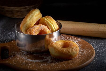 Donuts with sugar on a wooden plate on a dark table backgroundの写真素材