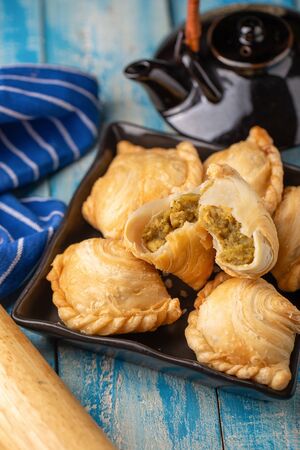 Homemade chicken Curry puffs on wooden table.