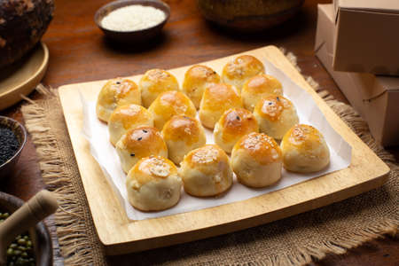 Chinese pastry filled with mung bean paste, taro, and salted egg in the paper box.