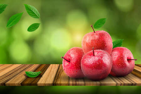 Natural farm fresh red apples on the board and green background.