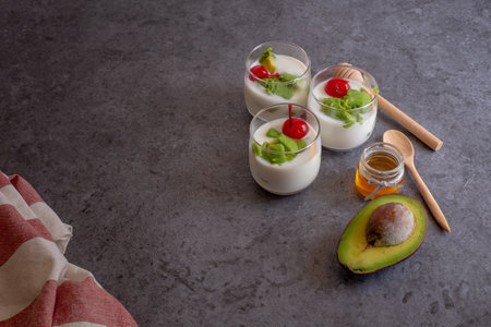 Glass of Cherry and avocado sliced in yogurt on wooden background.の写真素材