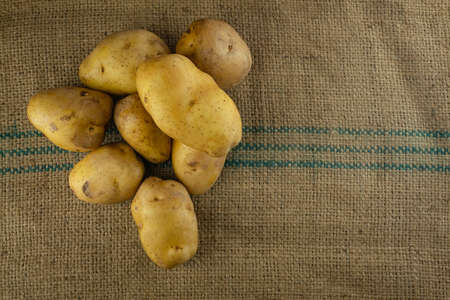 Raw potatoes for cooking on sack matsの写真素材