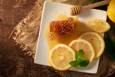 Lemon juice with honey on wooden table,  lemons and sage leaves.の写真素材