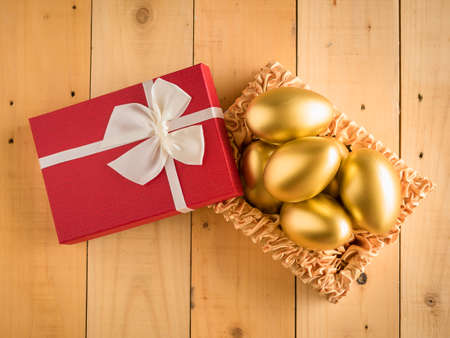 Financial success. Golden egg In a red gift box.の写真素材