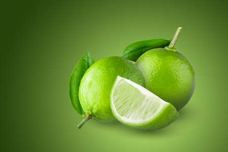 Whole and sliced limes, Sour green fruit isolated on a green background.