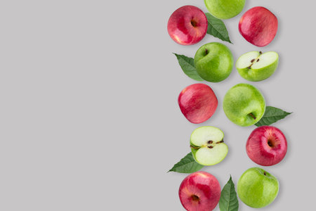 Creative layout made from red apple and green apple with green leaves on a pastel gray background. Fruit minimal concept. Flat lay, top view, and copy space.の写真素材