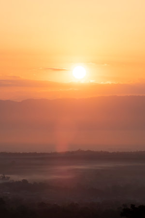 Beautiful morning scenery with Misty Mountain Morning Landscape with Fog and a Beautiful Sunrise Overlooking Hills, Valleys, and a Tranquil Lake, environmental themesの写真素材