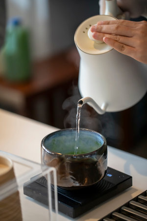 Pour hot water from the tea into the matcha bowl. A warm cup of matcha is made of finely ground...