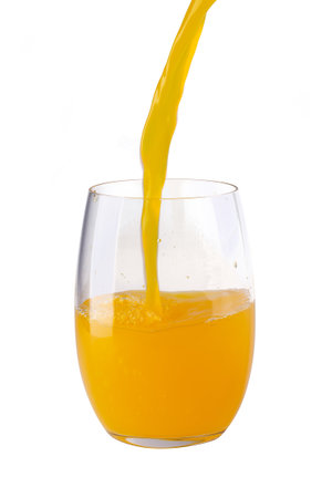 Fresh Orange Juice Being Poured into a Clear Glass isolated on a white backgroundの写真素材