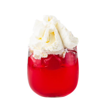 Strawberry jelly in a glass topping with cherries and whipped cream isolated on white background.の写真素材