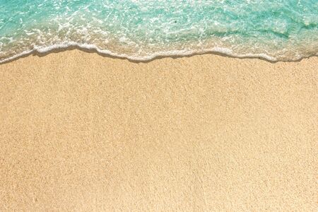 Soft waves with foam of blue ocean on the sandy beach