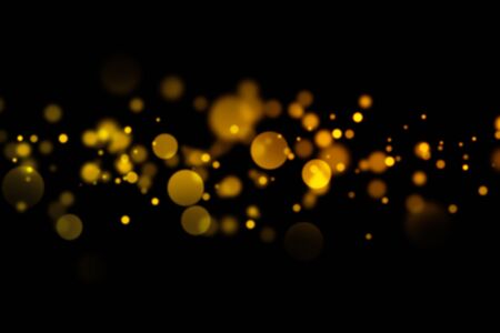 Golden light bokeh and abstract glittering on dark background. Sparkling dust particles.の写真素材