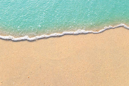 Soft waves with foam of blue ocean on the sandy beachの写真素材