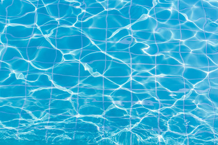 Blue swimming pool water surface and ripple wave background. Summer abstract reflection caustics in swimming pool.の写真素材