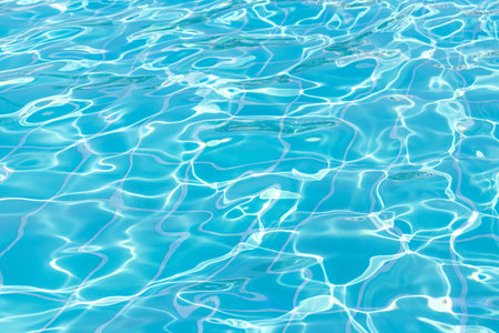 Blue swimming pool water surface and ripple wave background. Summer abstract reflection caustics in swimming pool.の写真素材