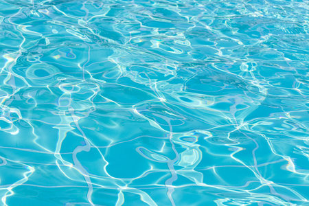 Blue swimming pool water surface and ripple wave background. Summer abstract reflection caustics in swimming pool.の写真素材