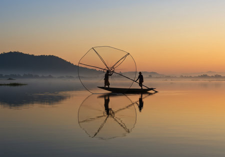 Fishermen at sunrise on the Inle Lake in Shan State in Myanmar in Southeastasia.