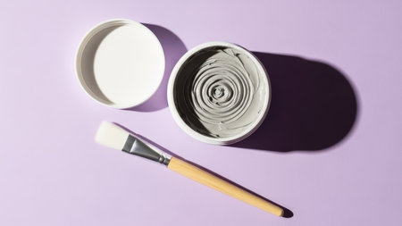 Brush and jar of cream on a purple background. Top viewの素材