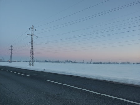 High-voltage power lines on the road at sunset. winter landscapeの写真素材