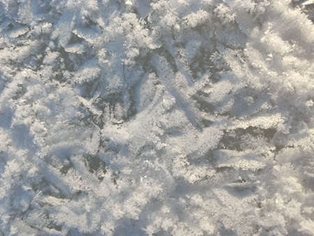 Close up of snow. snow texture. White crystals on ice. Tough winter. Frozen river close-up. Frozen...