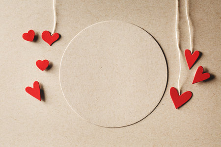 Handmade small paper hearts with strings on erthy colored paper backgroundの写真素材