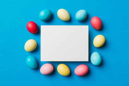 round frame multicolored Easter eggs with white blank paper on a brown background, close-up, space for text, blank for design, selective focus, tinted image.の写真素材