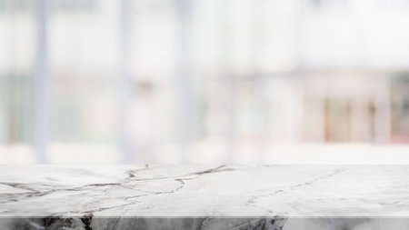 Empty white stone marble table top and blurred abstract interior from restaurant and coffee shop background - can used for display or montage your products.の写真素材