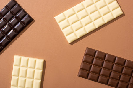 top view of delicious whole milk, white and dark chocolate bars on dark backgroundの写真素材