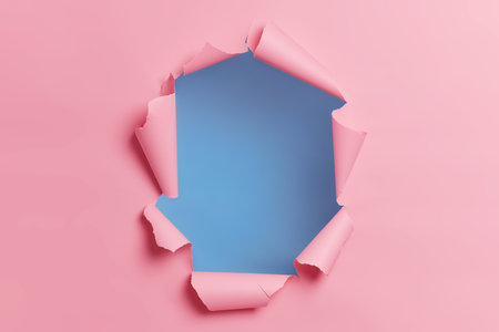 Torn ripped pink background with hole in center for your advertising content or promotion. Blank space to insert object. Abstract horizontal shot. Breakthrough concept. Nobody at image. through paperの写真素材