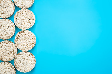 Puffed rice cakes on blue background, flat lay, top view, rice waffle, copy space.の写真素材