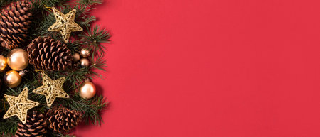 Christmas and New Year background with fir tree branches, golden Christmas balls and decorations on red backgroundの写真素材