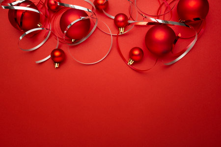 Christmas background with red baubles and ribbons on red backgroundの写真素材
