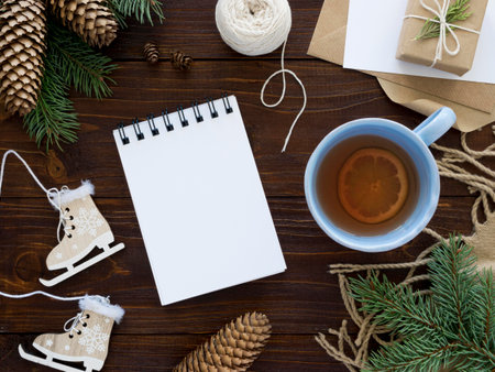 Christmas background. Cup of tea with lemon, gift box, christmas tree branches on dark wooden background top view.の写真素材
