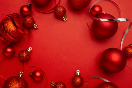Christmas background with red baubles and ribbons on red backgroundの写真素材