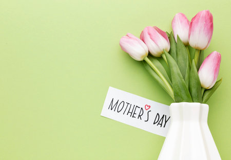 Mother's Day greeting card with tulips in vase on green background