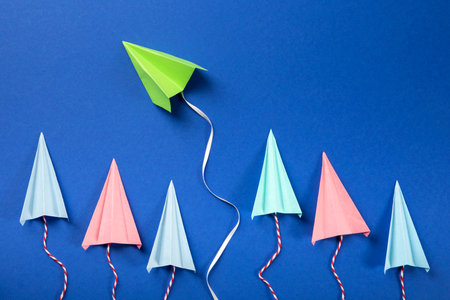 Paper airplanes on a blue background. The concept of leadership and success.