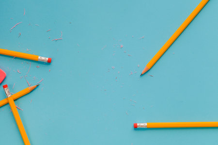 Yellow pencils with sharpening shavings and eraser on blue backgroundの写真素材