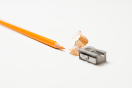 Pencil sharpener and sharpener shavings on white background