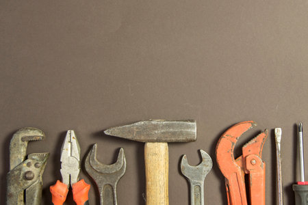 Construction tools on textured grunge paper consisting of pipe wrench, screwdriver, metal, hammer...