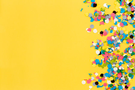Colorful confetti on yellow background. Flat lay, top view.の写真素材