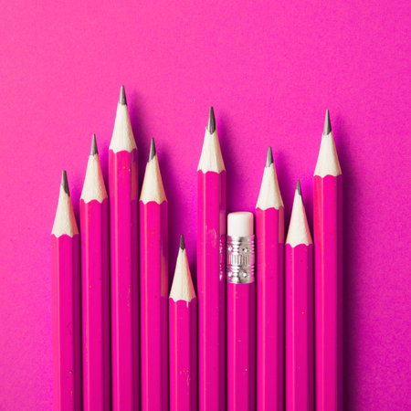 Pencils and eraser on a pink background, top view