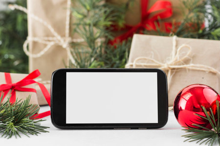 Smartphone with blank screen and christmas gift boxes on white backgroundの写真素材