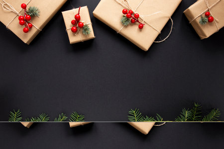 Christmas composition. Gifts, fir branches on black background. Flat lay, top view, copy spaceの写真素材